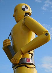 [photo, Oversized replica of yellow crash-test dummy with safety belt, Motor Vehicle Administration, 6601 Ritchie Highway, NE, Glen Burnie, Maryland]